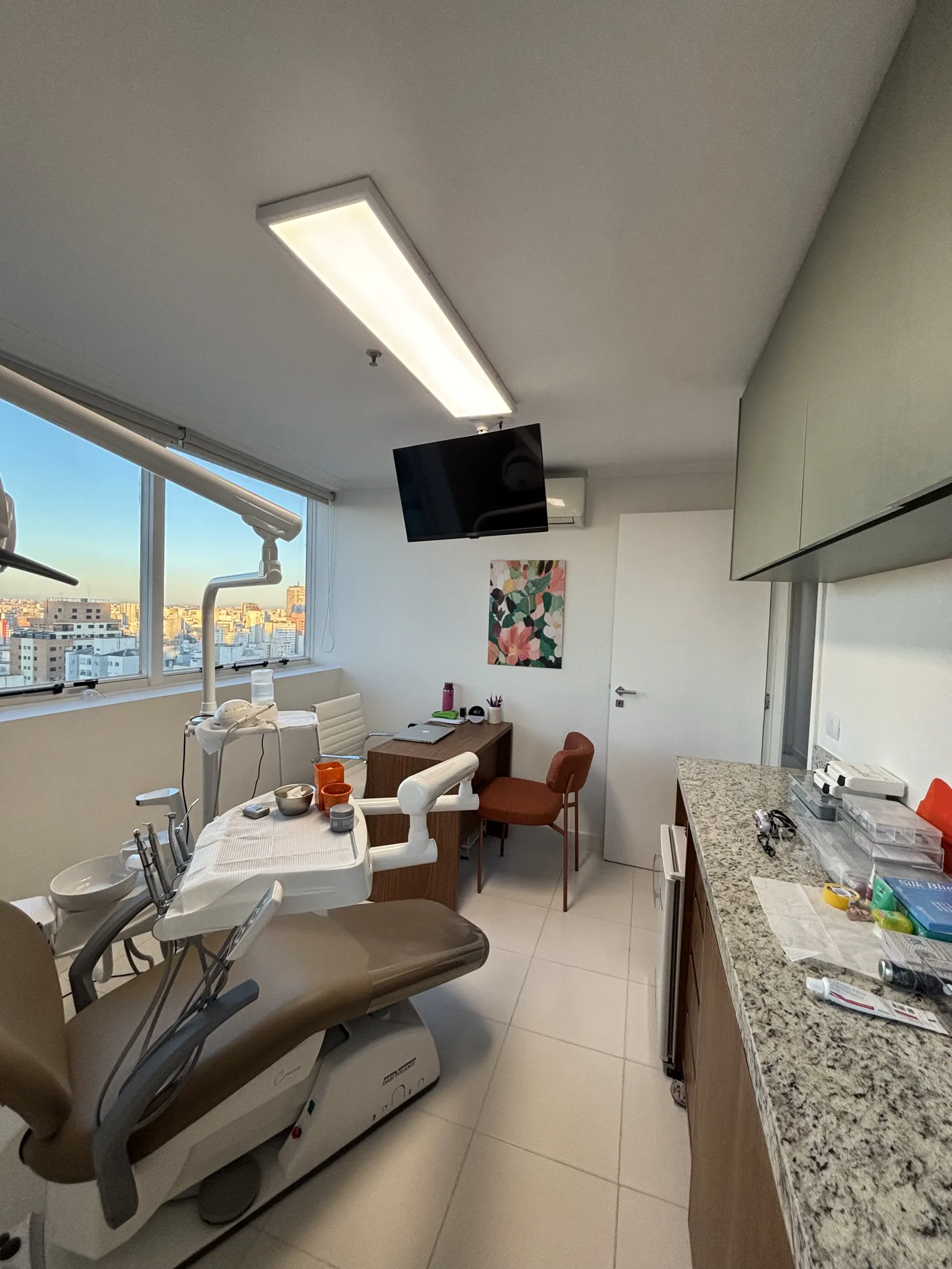Vista da sala odontológica com bancada, armários e ar-condicionado
